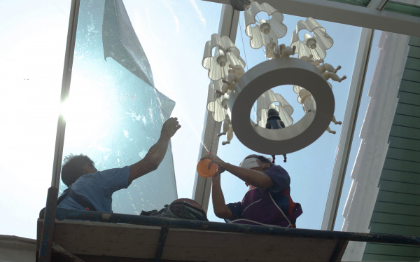 foto monteurs die raamfolie aanbrengen op dakraam